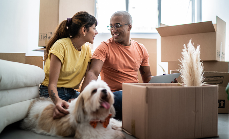 family with dog unpacking moving boxes