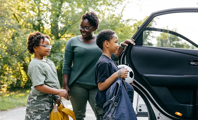 woman getting children into her car