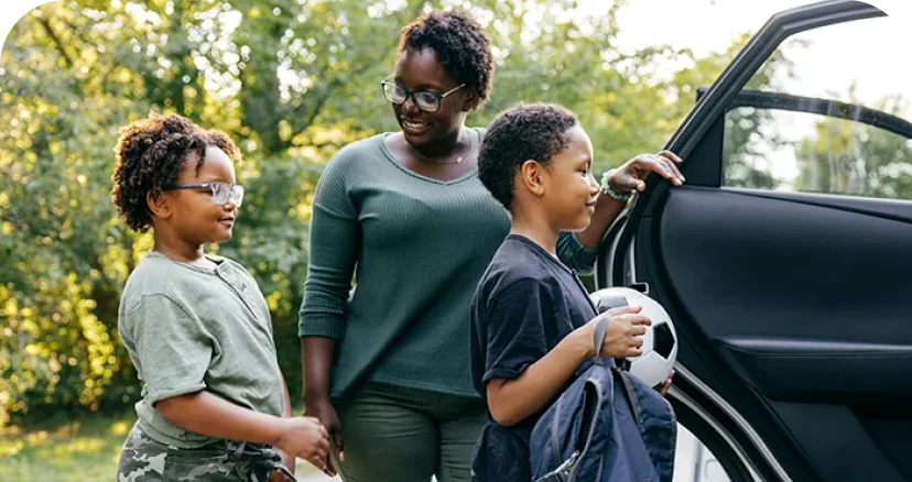 woman getting kids into her car