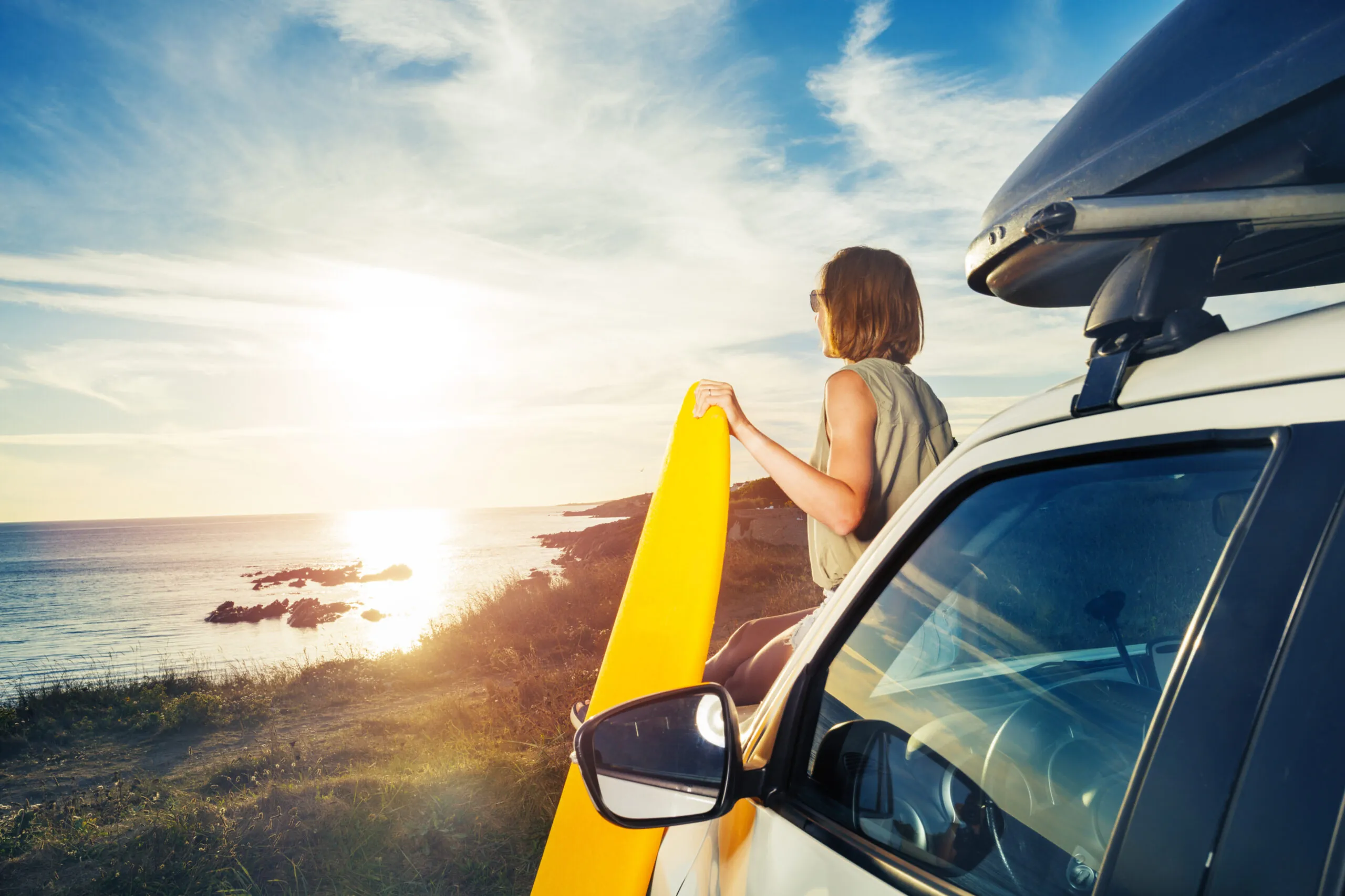 woman with surfboard looking at the ocean