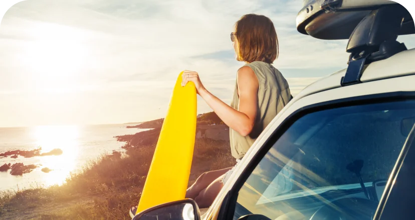 woman with surfboard by the beach