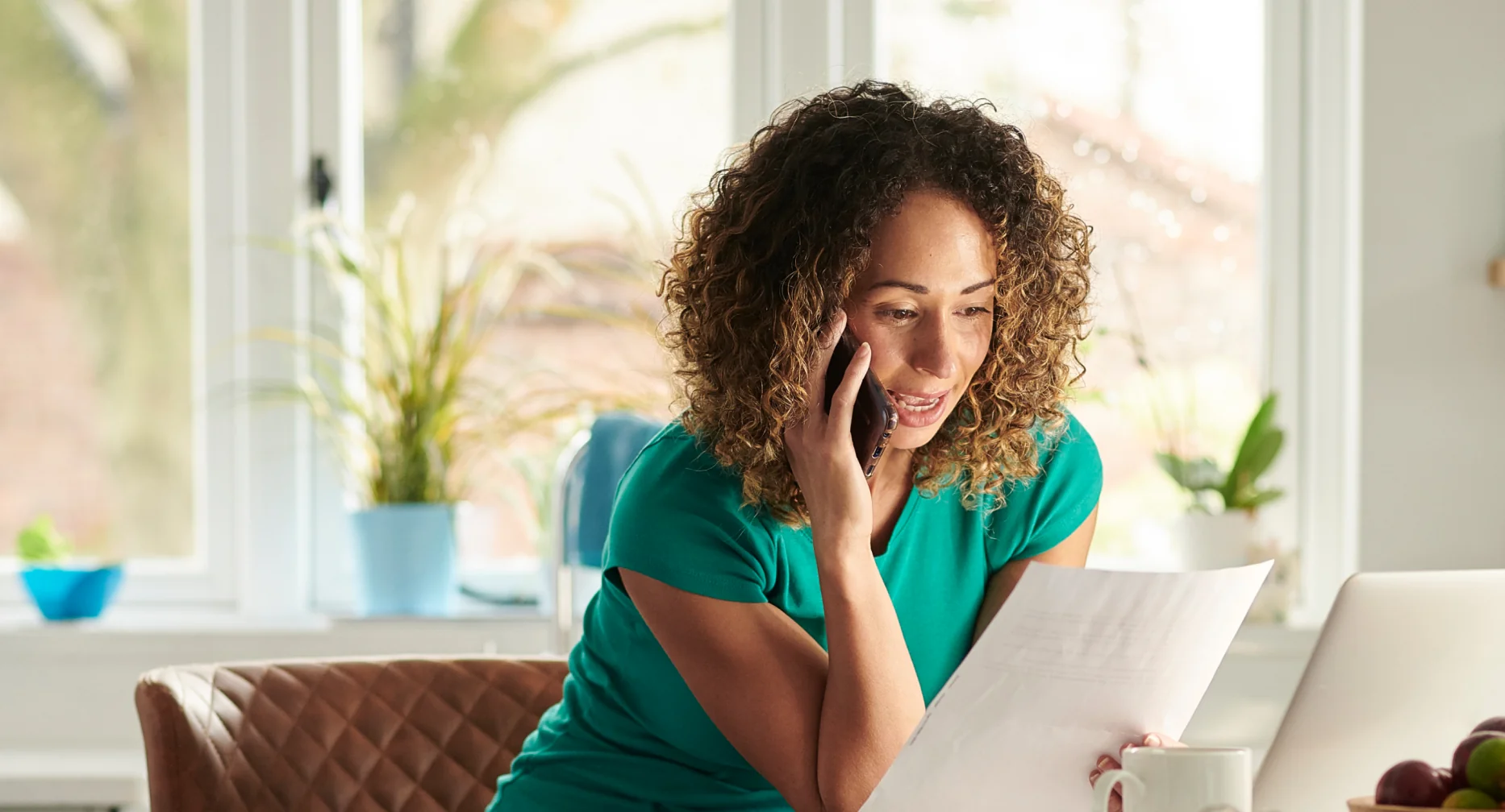 woman on the phone looking at bills